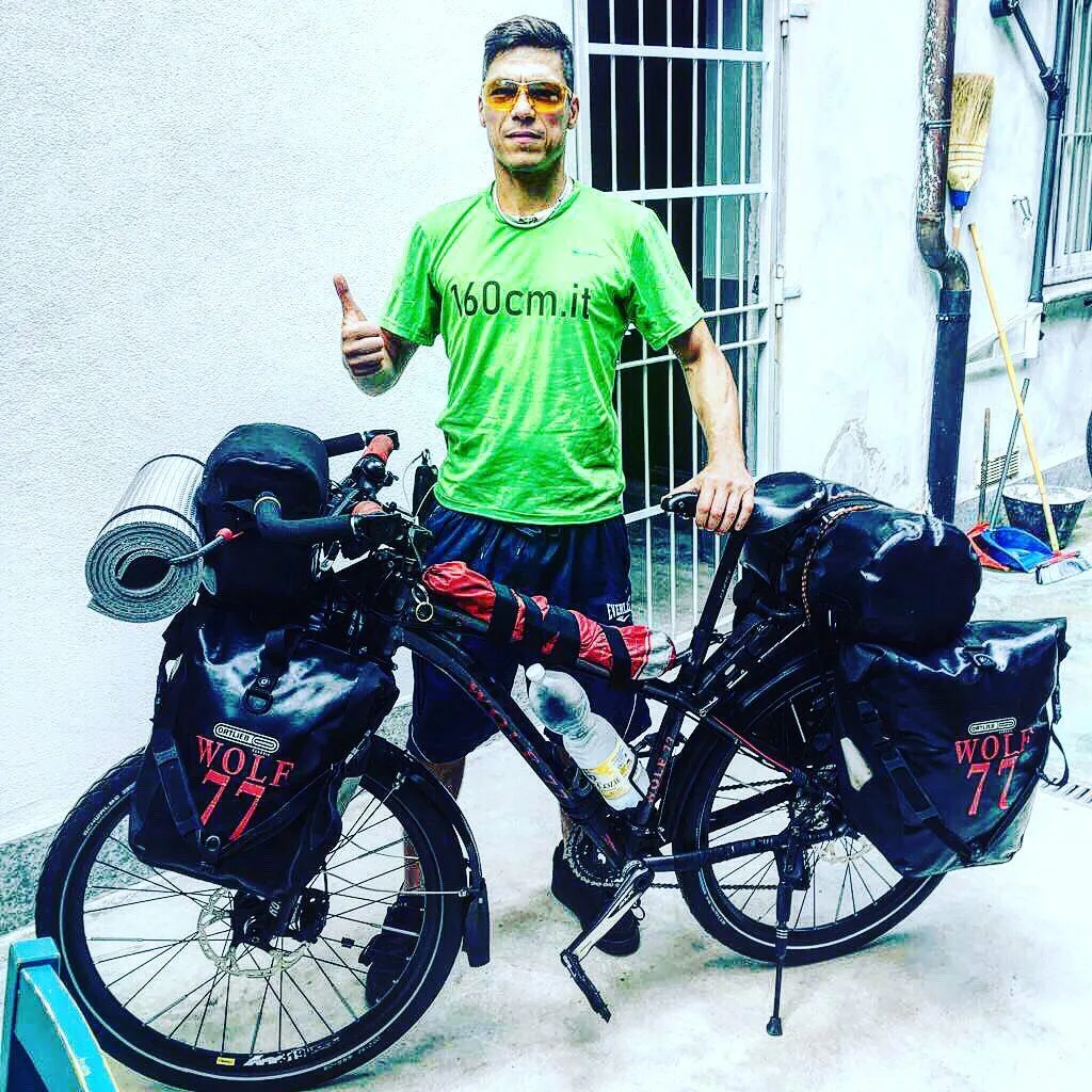 Fabio con la sua bicicletta da viaggio carica di borse, pronto a partire